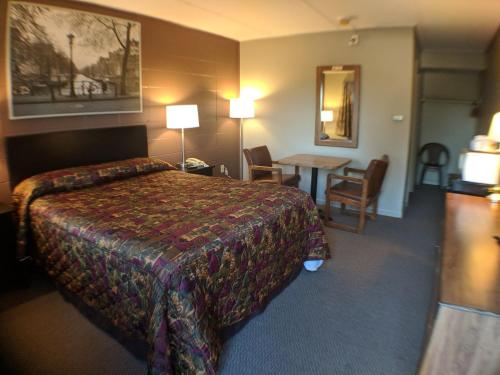 a hotel room with a bed and a table at Attican Motel - Attica - Batavia - Warsaw - Darien Lake in Attica
