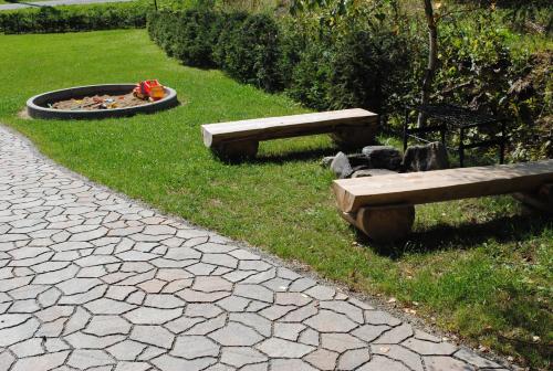 two benches sitting in the grass next to a fire pit at Roubenka-Mila in Ostružná
