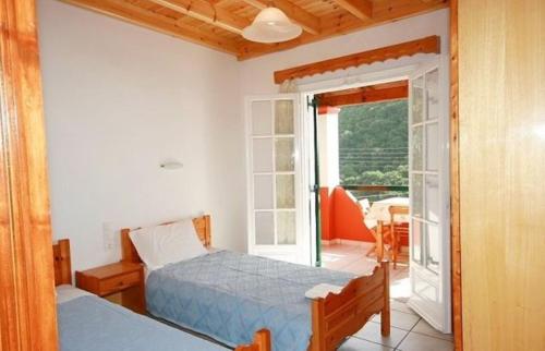 a bedroom with two beds and a balcony at Paleopalace in Paleokastritsa