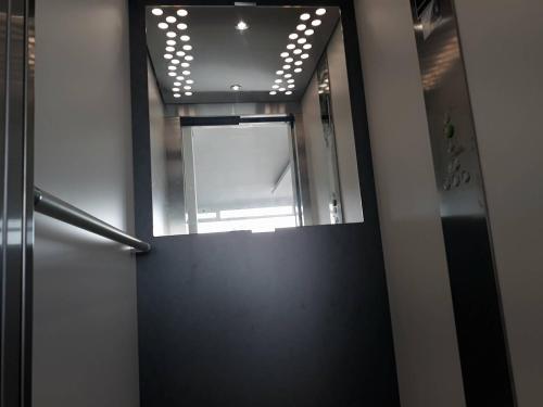 a hallway with a mirror and a door with a window at Pousada Tires Guest House in São Domingos de Rana