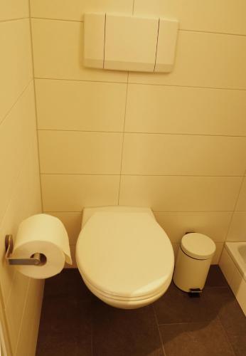a bathroom with a toilet and a toilet paper dispenser at Adventure Hostel Interlaken in Interlaken