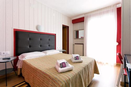a bedroom with a large bed with two towels on it at Hostal Fabrellas in Caldes de Malavella