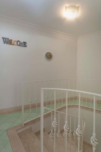 a white bed in a room with a clock on the wall at Casa Pamela in Capri