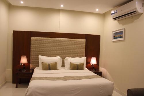 - une chambre avec un grand lit et deux lampes dans l'établissement ماسة داركم للوحدات السكنية, à Buraydah