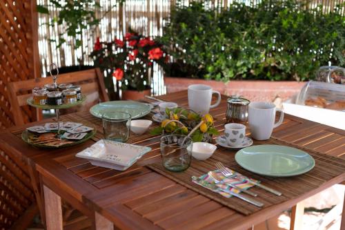 a wooden table with plates and dishes on it at Casa Pamela in Capri