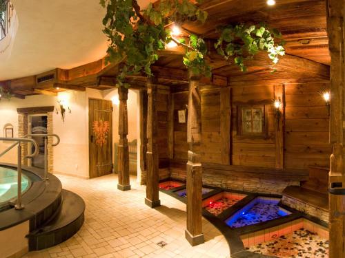 a room with a tub in a wooden house at Alpenhotel Tirolerhof in Neustift im Stubaital