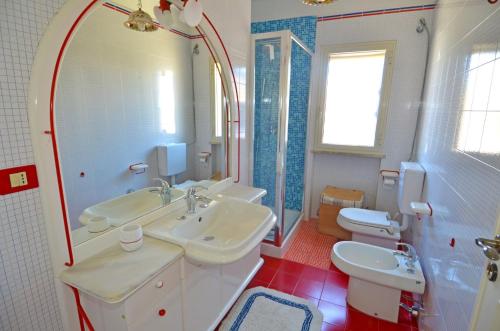 a bathroom with two sinks and a toilet and a mirror at Casa Tramonto - RosariaVacanze in Leuca