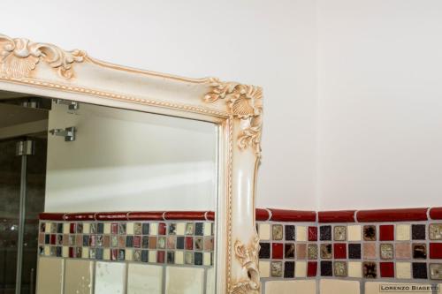 a mirror with a gold frame on a wall at B&B Geolja in Gioia Tauro