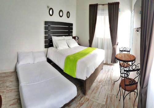 a bedroom with two beds and a window and a bed at Casa Hotel Santa Helena Boutique in Villa de Leyva