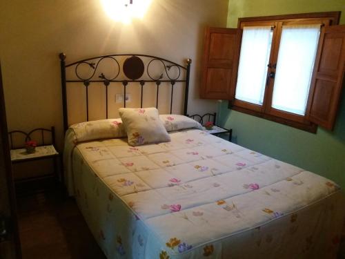 a bedroom with a large bed with a metal headboard at Apartamentos La Condesa in Valmeo