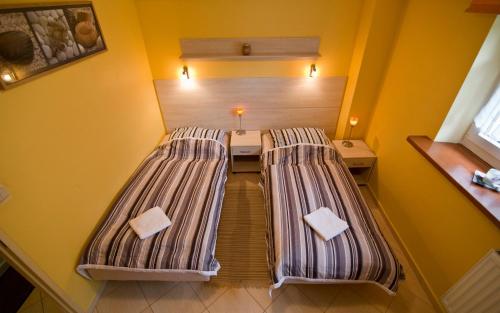 two beds in a room with yellow walls at Willa Asia in Szklarska Poręba