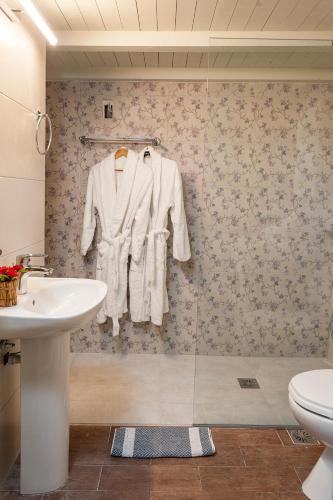 a bathroom with a sink and a white robe hanging on a wall at Filio House in Stalos