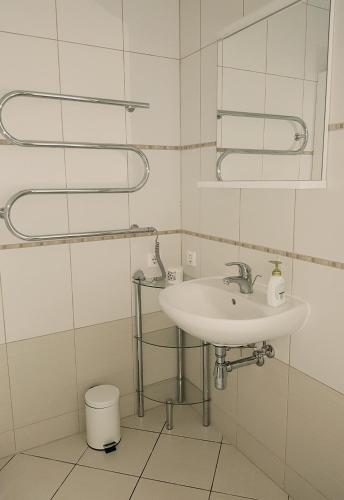 a white bathroom with a sink and a mirror at Miško apartamentai 50m2 in Juodkrantė