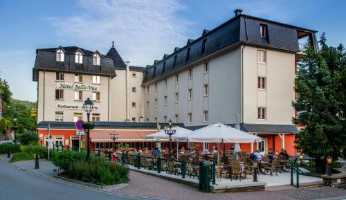 a building with people sitting at tables in front of it at Hotel Belle Vue in Vianden