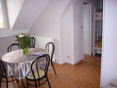 a dining room table with a vase of flowers on it at Aux Studios du Parc in Plombières-les-Bains