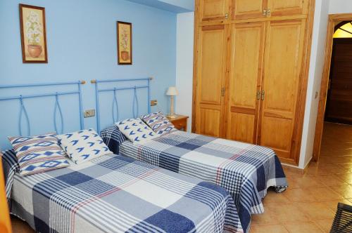 Dos camas en un dormitorio con paredes azules. en Villa PANORAMA y Villa MIRADOR, en Son Bou