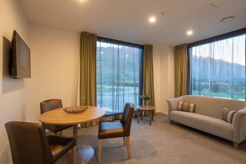 a living room with a couch and a table at Wyndham Garden Remarkables Park Queenstown in Queenstown