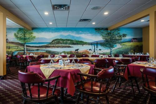 a dining room with tables and chairs and a mural at Shallow Bay Motel & Cabins Conference Centre in Cow Head