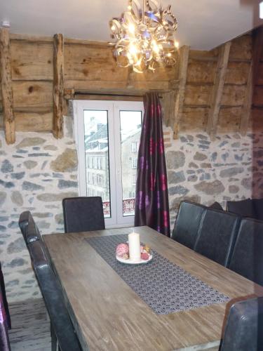 une salle à manger avec une table et un lustre dans l'établissement La Vallée, à Le Mont-Dore