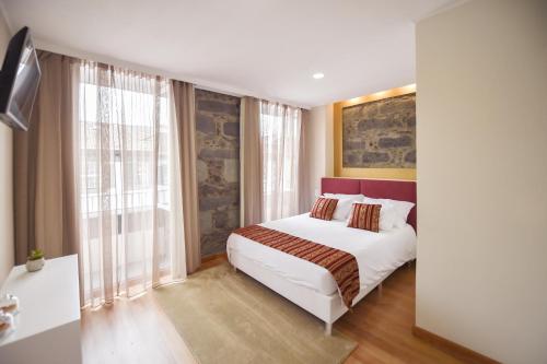 a bedroom with a bed and a large window at Horta Garden in Horta