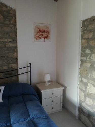a bedroom with a bed and a table with a flower on the wall at B&B Pozzo Innamorato in Montenero di Bisaccia