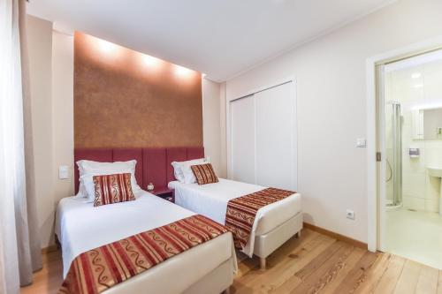 a hotel room with two beds and a window at Horta Garden in Horta