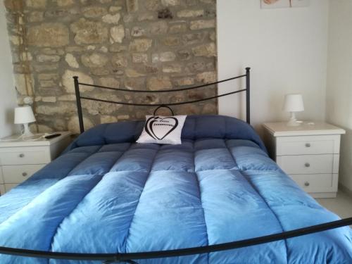 a bed with a blue comforter in a bedroom at B&B Pozzo Innamorato in Montenero di Bisaccia
