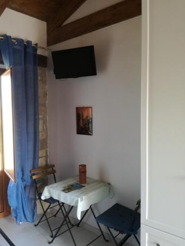 a room with a table and a tv on a wall at B&B Pozzo Innamorato in Montenero di Bisaccia