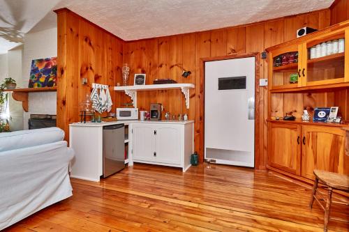 a kitchen with wooden walls and a white refrigerator at Auberge de la Tour et Spa in Magog-Orford