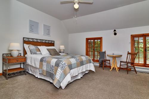 a bedroom with a bed and a table and chairs at Auberge de la Tour et Spa in Magog-Orford
