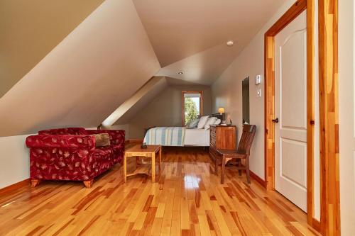a attic bedroom with a bed and a chair at Auberge de la Tour et Spa in Magog-Orford
