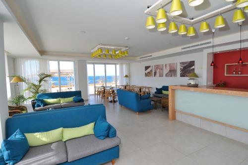 a living room with a blue couch and a bar at Artina Nuovo in Marathopolis