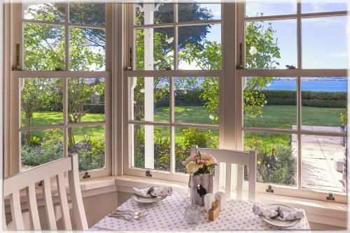 a table with two chairs in front of a large window at Bellevue Boutique Lodge in Taupo