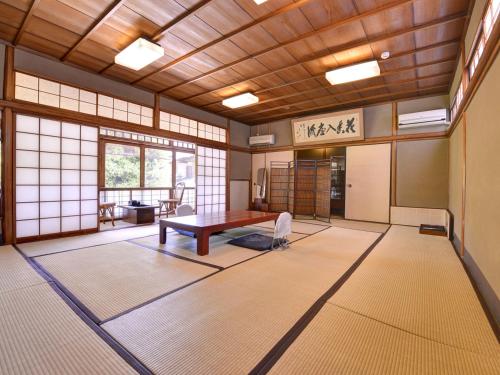 Habitación con mesa y sillas. en Ryokan Inakatei, en Kioto