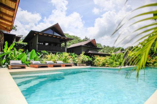 a villa with a swimming pool in front of a house at Lua Villas in Santa Teresa Beach