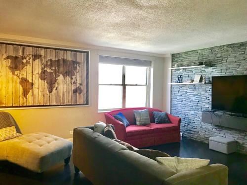 a living room with a couch and a tv at Wine Down Downtown ATL 14J in Atlanta