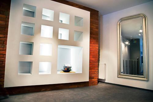 lustro na ścianie obok ściany z cegły w obiekcie Loft Suite w Łodzi
