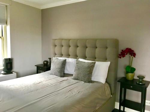una camera da letto con un grande letto bianco con cuscini di Wine Down Downtown ATL 14J ad Atlanta