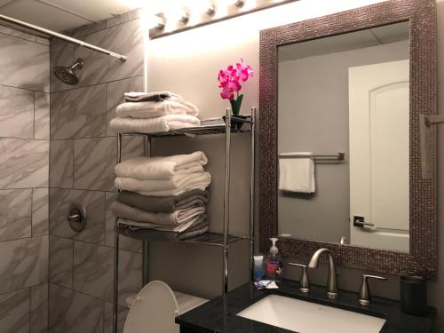 La salle de bains est pourvue d'un lavabo et d'une étagère avec des serviettes. dans l'établissement Wine Down Downtown ATL 14J, à Atlanta