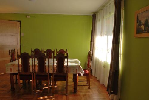 comedor con paredes verdes, mesa y sillas en La Casa Toesca, en Valdivia