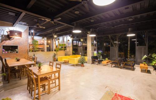 a restaurant with tables and chairs and a yellow couch at 達芭凱民宿 Tabakai B&B in Xinyi