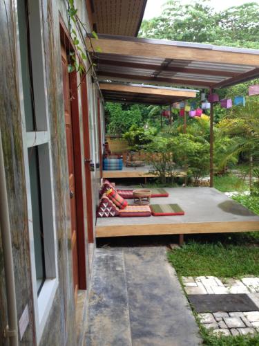 a patio with a couch under a pergola at Milin Guesthouse in Chiang Rai