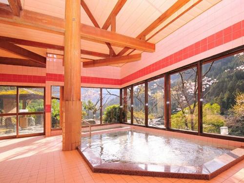 a swimming pool in a house with windows at Kazuraya in Miyoshi