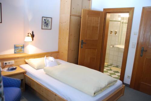 a bedroom with a bed and a bathroom with a shower at Der Erlhof Restaurant & Landhotel in Zell am See
