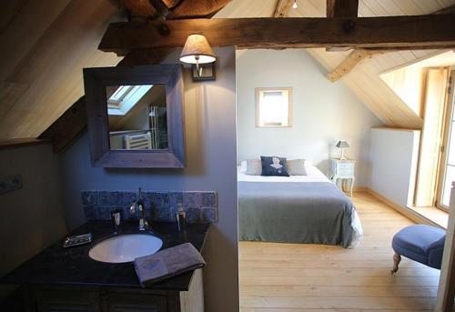 a bathroom with a sink and a bed in a room at Domaine de la Fouardière in Mulsans