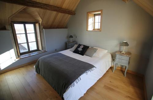 a bedroom with a bed and two windows at Domaine de la Fouardière in Mulsans