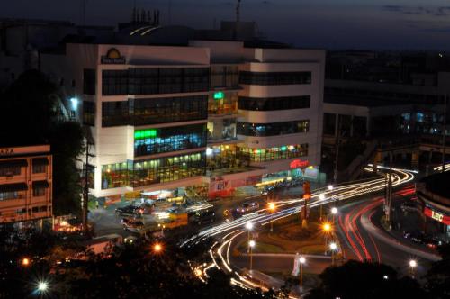 a city at night with traffic in front of a building at Days Hotel by Wyndham Iloilo in Iloilo City