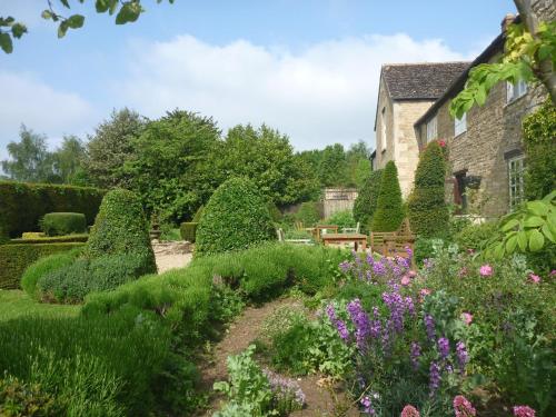 a garden with bushes and flowers in front of a building at The Barnsdale, Rutland in Oakham