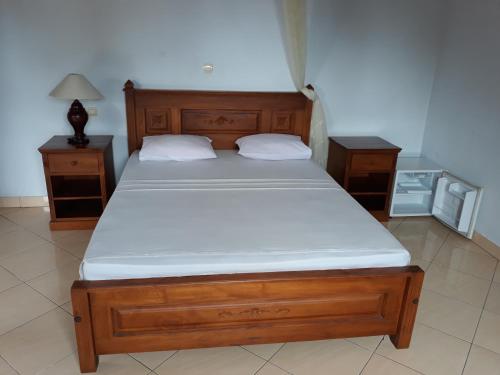a bed in a room with two nightstands and a bed sidx sidx sidx at Gede Homestay in Lovina