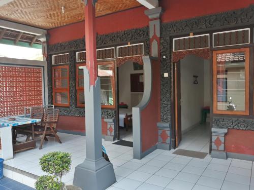 an outside view of a building with a table and chairs at Gede Homestay in Lovina